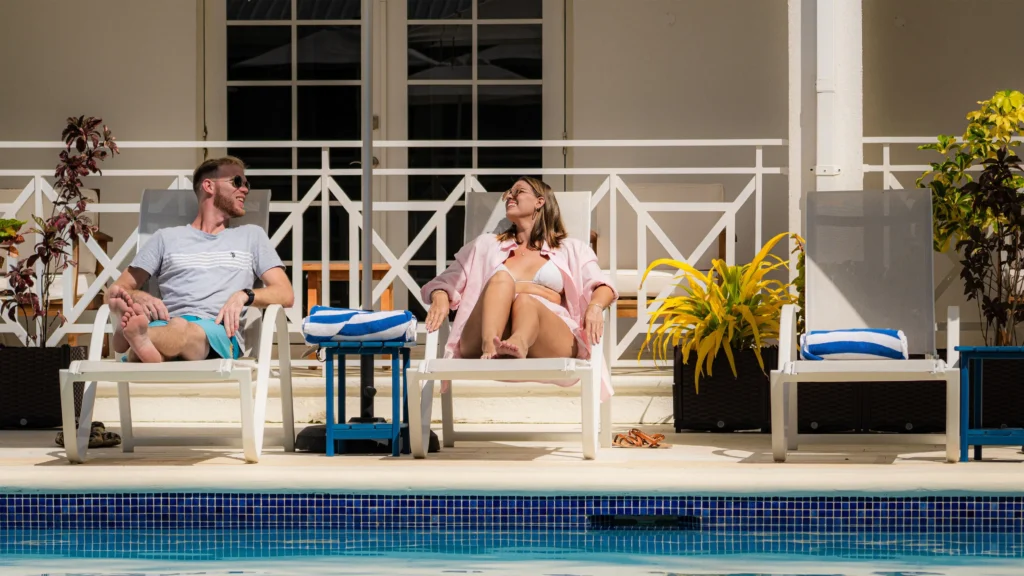 Couple relaxing on lounge chairs beside a pool at South Point Hotel.